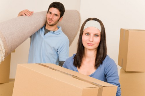 Professional movers carrying household items through a central London property