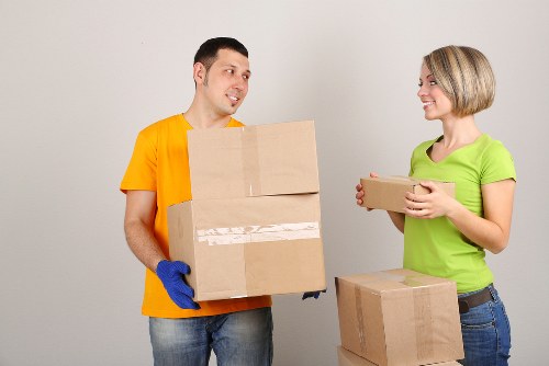 Movers carrying boxed belongings and furniture from a central London flat