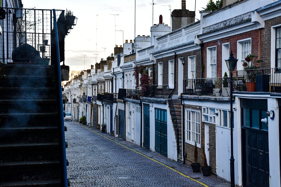 A narrow street in Canonbury Terrace lined with residential brick buildings, some with white painted lower walls and others with exposed brick facades. The street features a double yellow line on eith